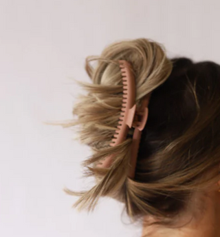 Hairbrush in a person's hair on a white background