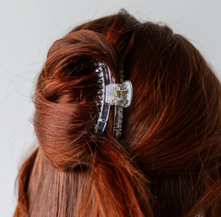 Close-up of a hair clip in red hair on a white background