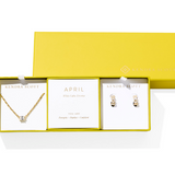 Jewelry set with necklace and earrings in a yellow box, featuring Kendra Scott branding.