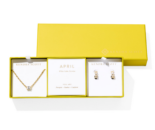 Jewelry set with necklace and earrings in a yellow box, featuring Kendra Scott branding.