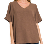 Brown V-neck t-shirt worn by a person on a white background