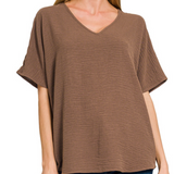 Brown V-neck t-shirt worn by a person on a white background
