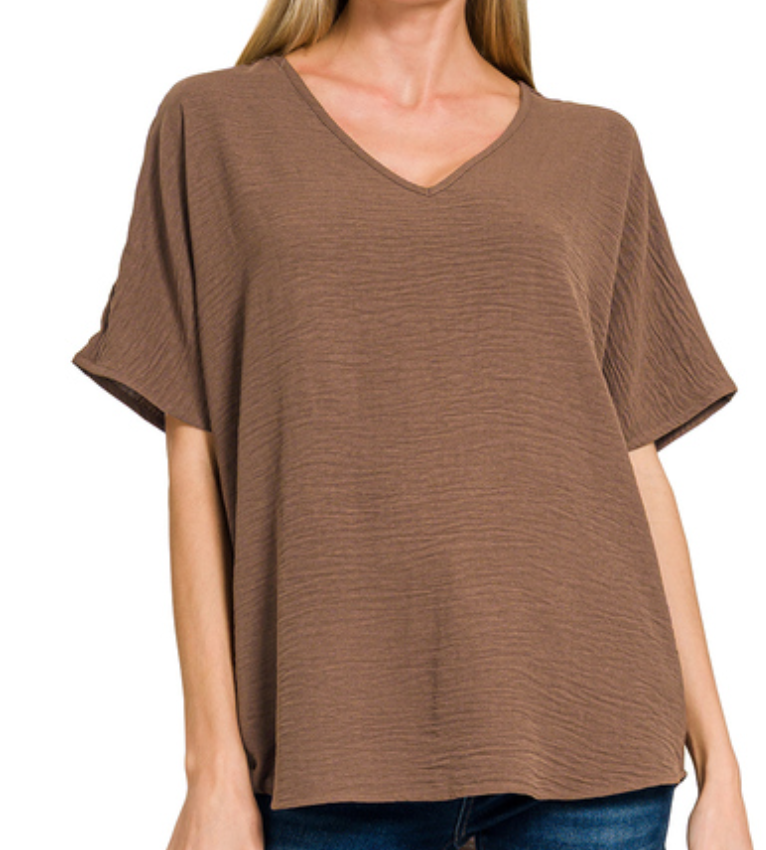 Brown V-neck t-shirt worn by a person on a white background