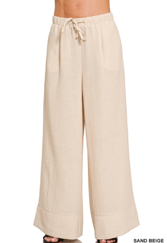 Beige wide-leg pants with a drawstring waist on a white background