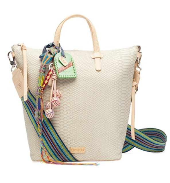 Beige woven handbag with colorful strap and decorative charms on a white background