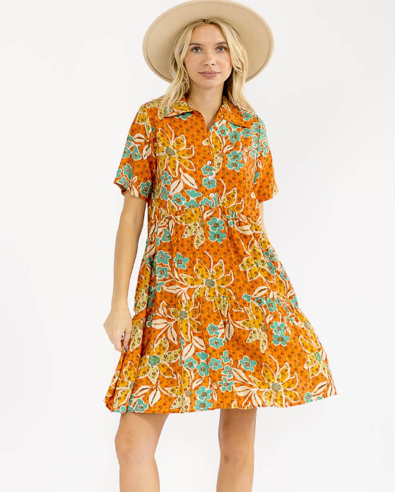 Woman wearing an orange floral dress with a white background
