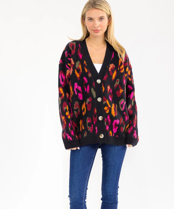 Woman wearing a colorful leopard print cardigan on a white background