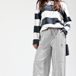 Person wearing a striped sweater and checkered pants on a white background