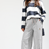 Person wearing a striped sweater and checkered pants on a white background
