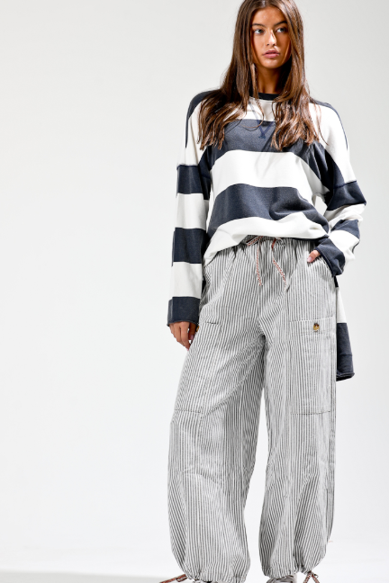 Person wearing a striped sweater and checkered pants on a white background