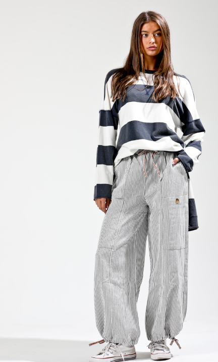 Person wearing a striped sweater and checkered pants on a white background
