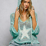 Woman wearing a teal crochet hoodie against a gray background