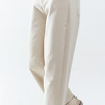 Person wearing light-colored pants and a blue shirt on a white background