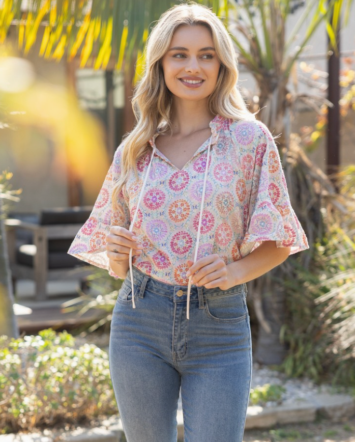 Woman wearing a floral blouse and jeans outdoors