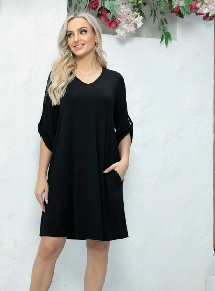 Woman wearing a black dress with floral decorations in the background