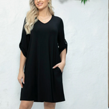 Woman wearing a black dress with floral decorations in the background