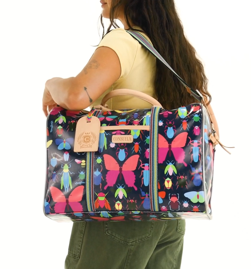 Woman carrying a colorful butterfly-patterned bag on a white background