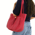 Person wearing a red shoulder bag on a white background