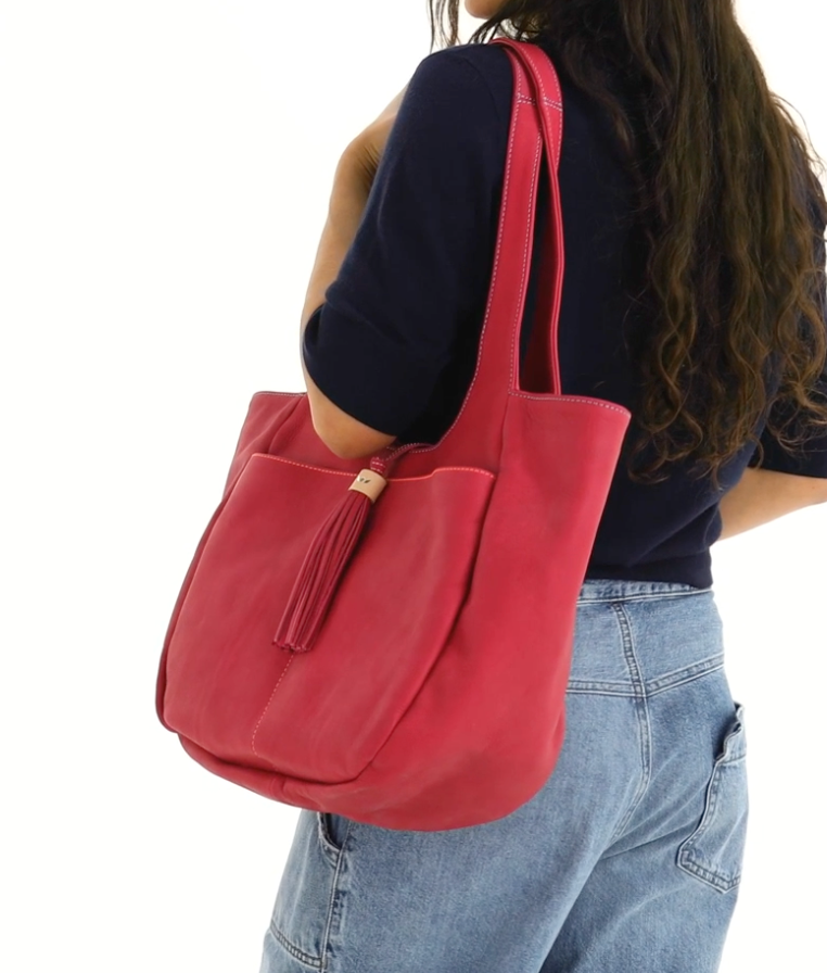 Person wearing a red shoulder bag on a white background