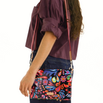 Person wearing a colorful patterned bag with a white background