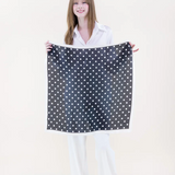 Woman holding a black and white polka dot fabric against a white background