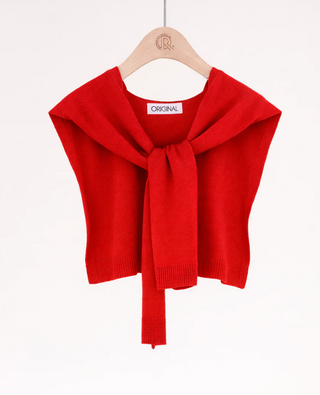Red knitted shrug with a bow on a hanger against a white background