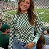 Woman in a checkered top and denim shorts at a sports event