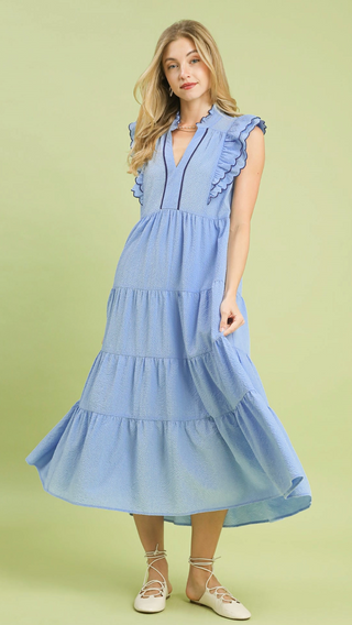 Woman wearing a light blue dress on a green background