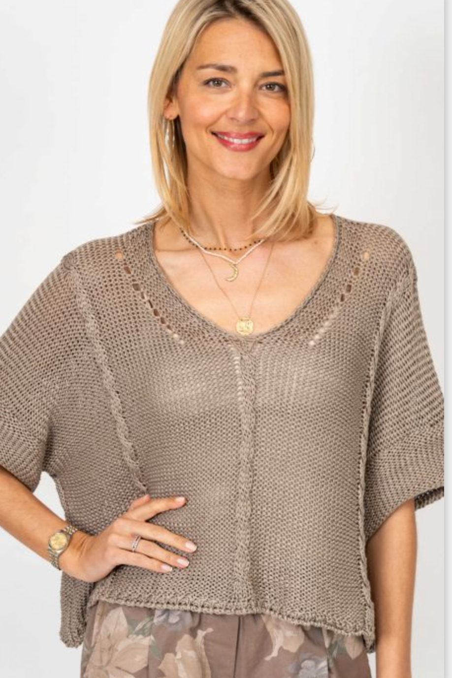 Woman wearing a brown knit top with a plain background
