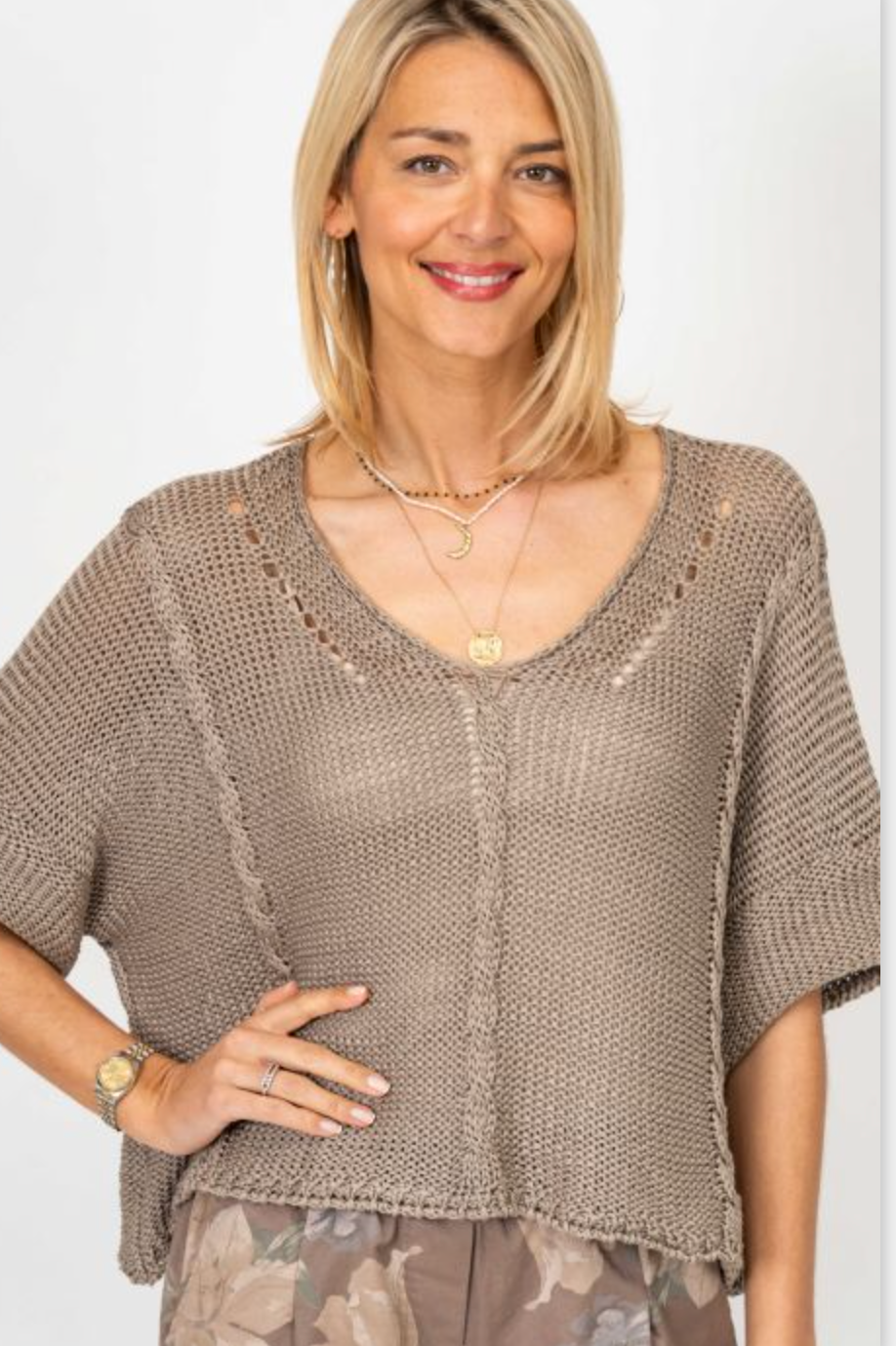 Woman wearing a brown knit top with a plain background