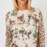 Woman wearing a long-sleeve shirt with horse and leopard print design.