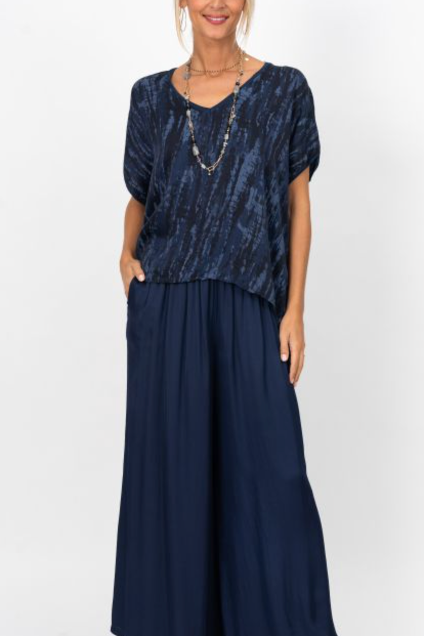 Woman wearing a navy blue dress with a patterned top on a white background