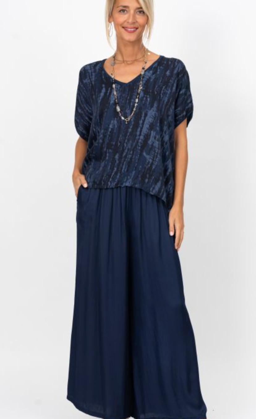 Woman wearing a navy blue dress with a patterned top on a white background