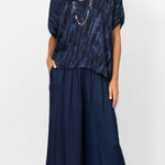 Woman wearing a navy blue dress with a patterned top on a white background