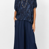 Woman wearing a navy blue dress with a patterned top on a white background