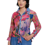 Woman wearing a colorful patterned shirt with a white background