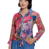 Woman wearing a colorful patterned shirt with a white background