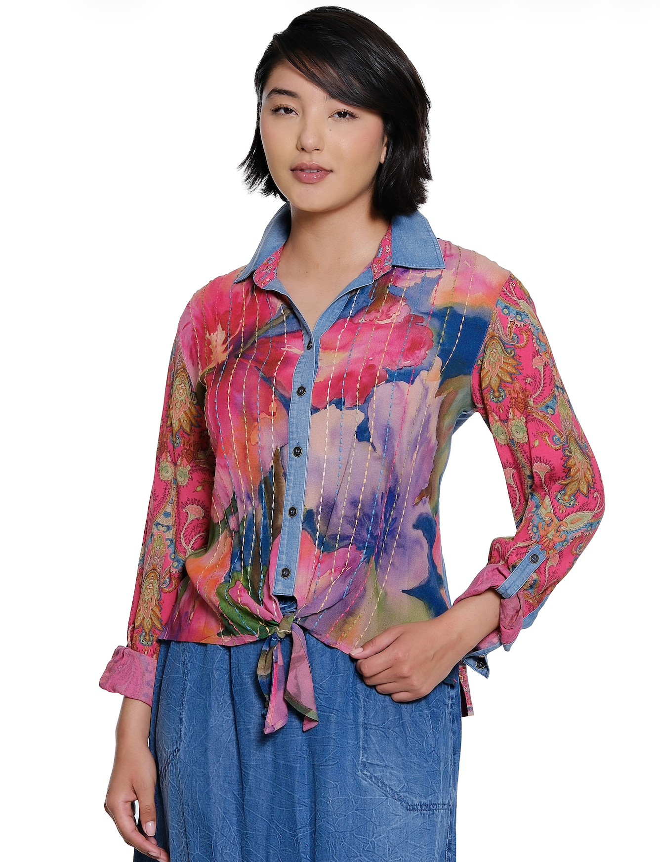 Woman wearing a colorful patterned shirt with a white background
