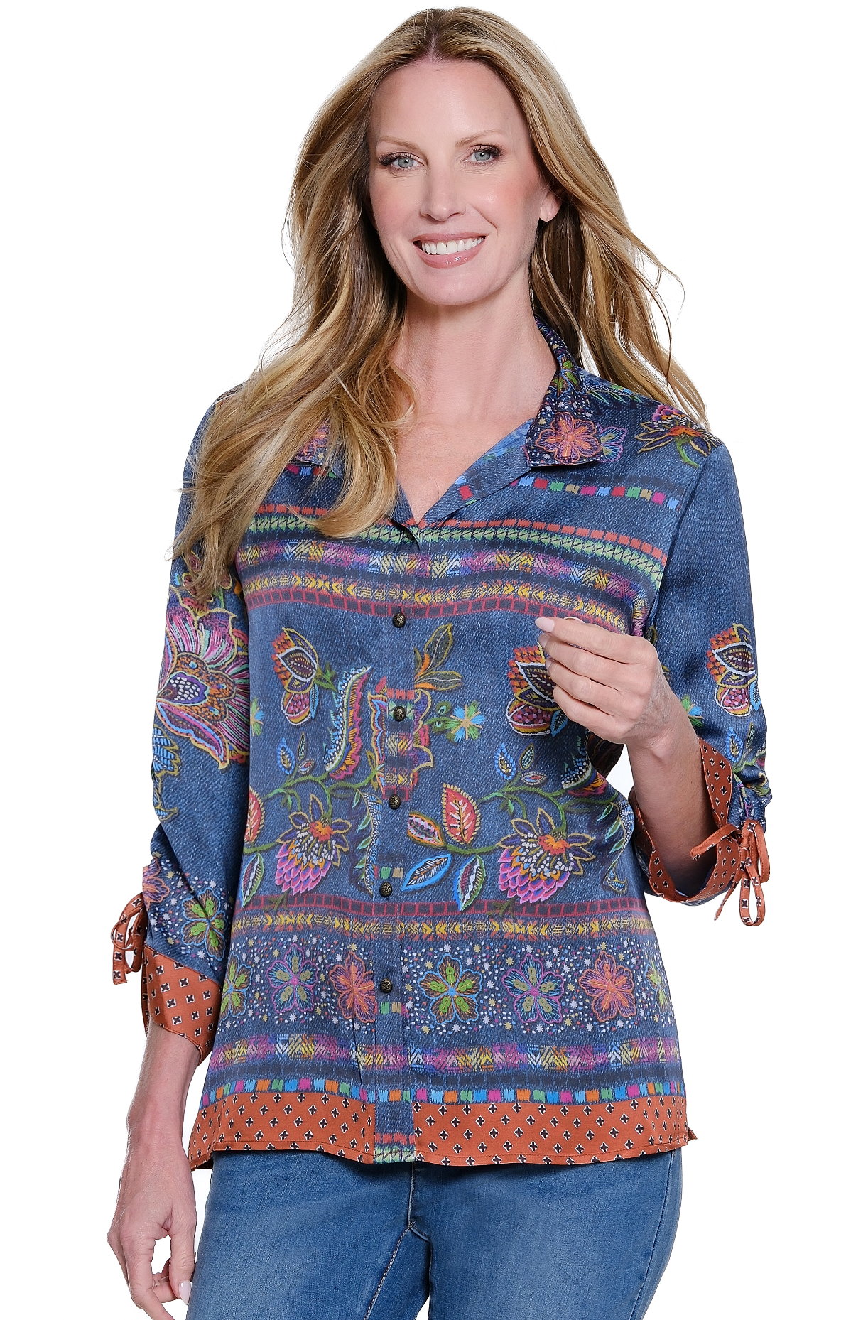 Woman wearing a colorful embroidered shirt with rolled-up sleeves on a white background