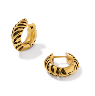A pair of gold huggie hoop earrings with a textured, ribbed openwork design, displayed on a clean white background.