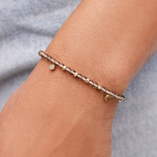 Bracelet on a wrist with a neutral background