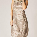 Woman wearing a floral dress against a plain background