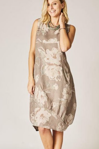Woman wearing a floral dress against a plain background