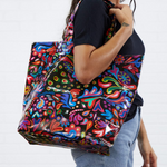 Person holding a colorful patterned bag against a white background