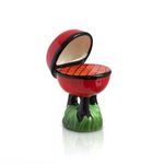 Small ceramic model of a barbecue grill with open lid on a white background