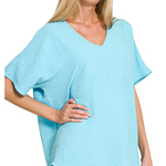 Woman wearing a light blue oversized top on a white background