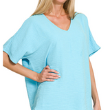 Woman wearing a light blue oversized top on a white background
