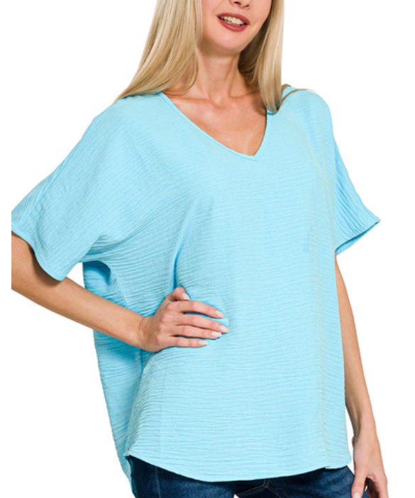 Woman wearing a light blue oversized top on a white background