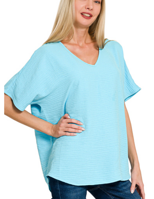 Woman wearing a light blue oversized top on a white background