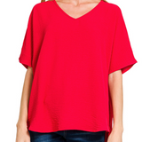 Red blouse worn by a person on a white background
